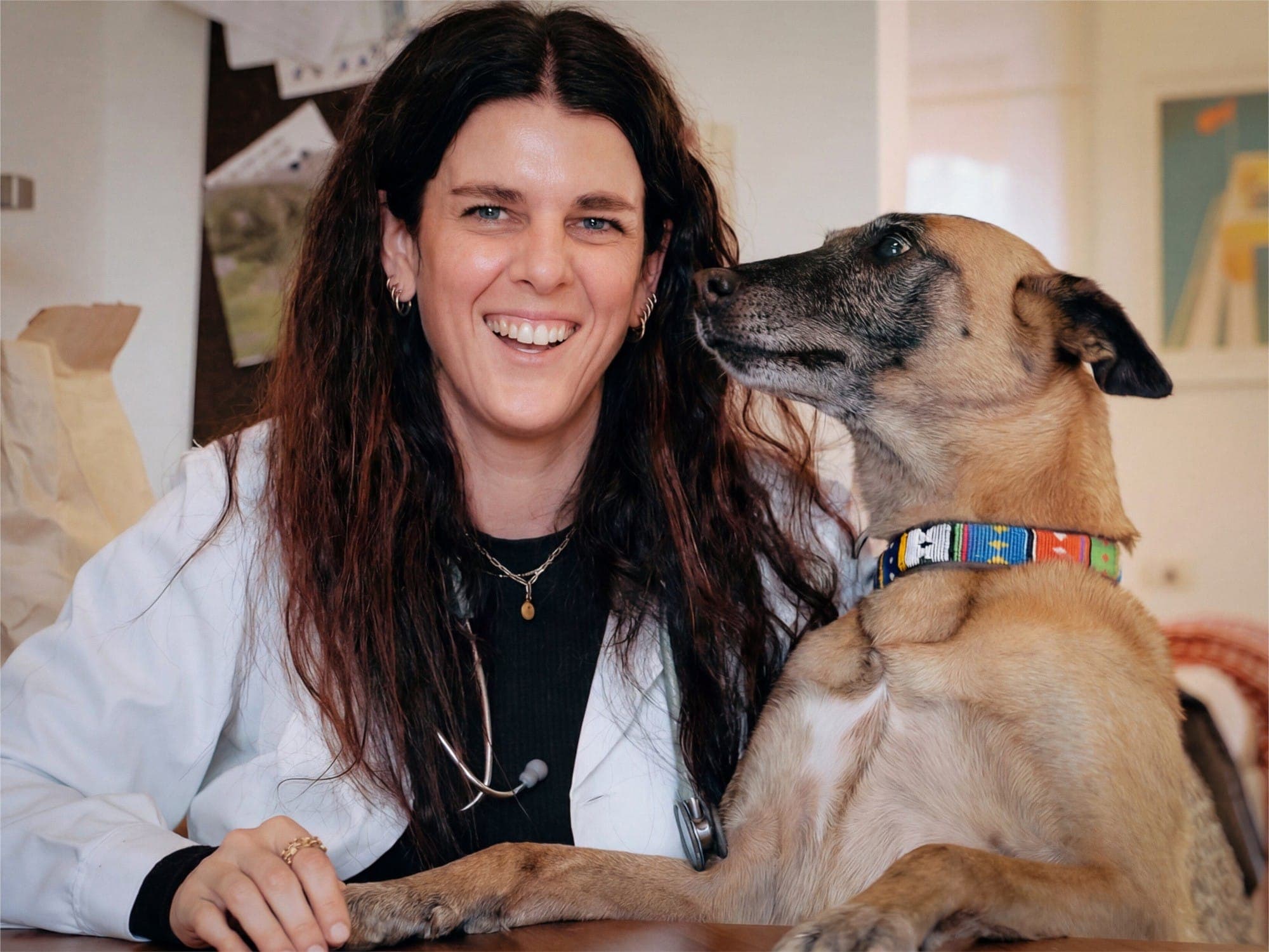 La dott.ssa Alessandra Calini sorridente in camice, accanto a un cane